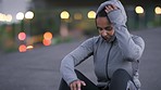 Night, woman or tired runner after fitness training, running exercise or workout resting on city street or road. Fatigue, mindset or exhausted sports athlete girl in hoodie relaxing or breathing 