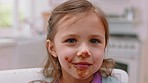 Messy, chocolate and face of girl in kitchen for food, candy and breakfast spread. Happiness, dessert and comic with sweets on mouth of child at home eating for sugar, cake and cocoa snack 
