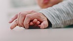 Child, mother and holding hands for support, love and family care with empathy, hope and trust together during sad time after loss or crisis. Hand of boy and woman on table at home for communication
