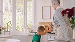 Happy, dancing and child with grandmother in kitchen while making breakfast on a summer weekend. Young boy with energy, fun dance and love spending time at home together with grandma while cooking.