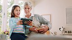 Grandmother, child and tablet in silly selfie, goofy or funny faces in the kitchen together at home. Grandma and little girl with touchscreen for fun moments, humor or making facial expressions
