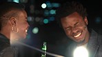 Party, laughing and black couple at a social, alcohol and birthday celebration event at night. Fun, comic and funny joke of a happy couple together with a beer and love in the dark with bokeh