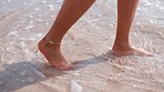 Relax, summer and feet in water at the beach enjoying holiday, vacation and weekend getaway in Maldives. Traveling lifestyle, freedom and legs of woman walking in ocean for calm, wellness and peace