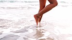 Legs, beach and woman relax with feet in water, fun and enjoying freedom, travel and holiday at the sea. Ocean, waves and girl feet walking in nature, freedom and summer seaside vacation in Miami