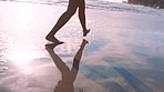 Woman feet, beach and walking on sand, water and summer vacation, holiday and tropical travel for wellness, freedom and lifestyle. Closeup, legs and barefoot jump on sea shore, sunshine and happiness