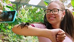 Phone, spider and friends with a girl children posing for a photograph with an arachnid outdoor at a zoo. Kids, glasses and nature with a female child taking a picture with a tarantula outside