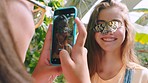 Phone, photography or girl with a butterfly on her face for social media in nature or zoo in summer. Happy children, content creation or excited teenagers taking fun pictures with beautiful animals