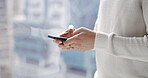 Hands, phone and texting by window for social media, chatting or online conversation at the office. Hand in communication, typing or browsing in research or discussion on smartphone at the workplace 