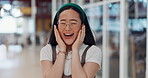 Good news, excited and wow with an asian woman looking surprised or shocked alone in an airport terminal. Laugh, funny and humor with a happy young female with a carefree or positive expression