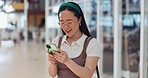 Phone, typing and Asian girl with smile at the mall online to check social media, internet and social network. Communication, technology and happy woman with smartphone at shopping mall on weekend