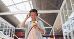 Asian man, phone and headphones for listening to music and dancing while walking in creative office with smile, happiness and positive mindset. Male entrepreneur during travel with network connection