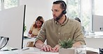 Call center, customer service and man talking, typing and on call with client, working on computer. Customer support, telemarketing and male worker busy on report, review and speaking in crm company