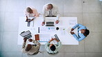 Business people, meeting and planning strategy above with technology in marketing, advertising or analytics at the office. Top view of marketing team in discussion with data, information or analysis