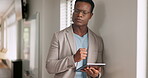 Tablet, thinking and research with a business black man leaning against a wall in his office at work. Management, idea and search with a male employee using tech to read an email or internet message