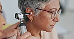 Nurse, ear or doctor consulting senior woman in an appointment checkup, hearing exam or testing audio results. Wellness, old woman or healthcare worker helping or checking tinnitus on elderly patient