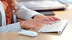 Closeup of the hands of a business woman typing on computer keyboard in an office using . Entrepreneur working on a computer, researching, compiling reports and planning in a startup company