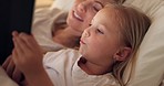 Tablet, mother and child on the internet in bed, streaming a movie or reading a book on the web at night. Education, learning and games on technology for a girl and her mom together in the bedroom
