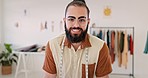 Creative man, fashion designer and face of tailor standing by work desk with smile for startup. Portrait of happy confident male manager smiling in clothing, fabric or garment in studio workshop