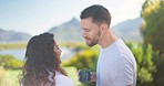 Couple, vacation and kiss with coffee in morning, lake and mountain for hug, romantic honeymoon and nature. Man, woman and love for start, sunshine and freedom with care on outdoor holiday at lodge