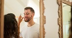 Face cream, skin and happy couple in home bathroom while at mirror together for facial health and wellness. Interracial man and woman funny while using natural dermatology cosmetics for self care