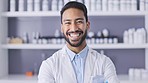 Pharmacist, medical doctor and portrait of a indian man ready for pharmacy consultation. Happy, healthcare employee and pills on clinic shelf of a health consultant laughing with a smile at work