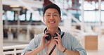 Man, face and headphones in mall with smile, music and walking for shopping, urban adventure or travel. Young asian guy, happy and streaming online for podcast, audiobook and digital tech in Tokyo