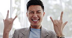 Face, winner and rock on with a business asian man feeling excited or motivation while standing alone in his office at work. Portrait, hand gesture and sign with a male employee posing as a rocker