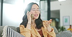 Phone communication, talking and asian woman at home on a sofa with a online conversation. Phone call, speaking and networking of a person on a mobile phone at a living room house on a couch