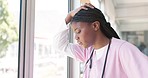 Doctor, woman and burnout by window with stress, headache or sad in hospital workplace with hand on head. Black woman, medic and mental health problem at clinic with anxiety from work in healthcare
