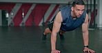 Fitness, energy and man doing pushups at the gym, training body and focus on health with a workout. Exercise, power and strong athlete with a cardio routine for muscle, performance and strength