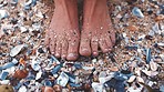 Woman feet in sand with sea shell on the beach during summer vacation. Person toes, pedicure and skin on the ocean shore with sandy foot while relax on the weekend or travel holiday in nature