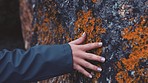 Hands, rock and nature with the hand of a woman touching rocks, a stone or a boulder on the beach. Freedom, feeling and contact with a female running her fingers across a rocky surface outside