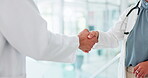 Doctor, tablet and handshake in partnership for agreement, deal or greeting in discussion at hospital. Healthcare professionals shaking hands for b2b, collaboration and sharing touchscreen in trust