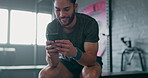 Phone, fitness and man relax in gym tracking workout, exercise or progress on break. Technology, sports and happy male with mobile smartphone for internet browsing, text messaging or social media.