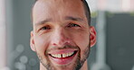 Face, happy and hope with a man indoor on a gray background feeling positive, carefree or cheerful. Portrait, smile and inspired with a handsome young male standing inside alone looking joyful