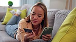 Asian woman, phone and credit card in ecommerce on sofa lying in the living room for online shopping at home. Female shopper on smartphone for internet banking, app or transaction relaxing on couch