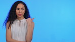 Portrait, doubt and mockup with a black woman in studio pointing to a blue background for marketing or advertising. Frown, mock up and product placement with an attractive young female on blank space