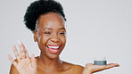 Face, product and beauty with a model black woman in studio on a gray background for skincare treatment. Portrait, wink and lotion with an attractive young female indoor to apply facial moisturizer