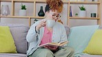 Black woman, reading and coffee on a living room sofa feeling relax and calm at home. Lounge, house and book read of a young person on a couch resting with books and university textbook in morning