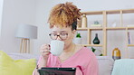 Black woman, coffee and tablet on couch and social media post, internet blog or reading ebook online for inspiration. Young person video streaming, sofa drinking tea and ideas on digital technology