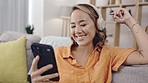 Social media, enjoying and woman with music and a phone for communication, podcast or chat. Happy, laughing and Asian girl reading a mobile text on an app while listening to audio with headphones