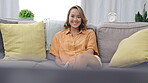 Happy woman on couch watching tv for funny show, film or comedy movie at home in her living room or apartment. Television, relax and face of asian female with remote on sofa on live streaming service