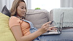 Asian woman, credit card and laptop online shopping, ecommerce or fintech easy payment on couch. Young person in China typing bank information on computer, financial transaction and web 3.0 on sofa