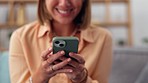 Woman, hands and phone on sofa for social media, chatting or texting in living room at home. Hand of happy female typing on smartphone for chat, browsing or mobile app on the lounge couch indoors