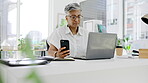 Business woman, phone and laptop at desk in office for planning, online management and administration. Mature female working on smartphone, computer and technology of multitasking on media connection