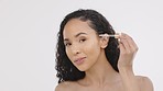 Face, black woman and pipette with serum, skincare and dermatology against a grey studio background. Portrait, African American female and lady with essential oil, cosmetics and beauty with soft skin