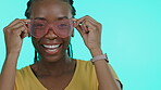 Face, fashion and shades with a black woman in studio on a blue background to model eyewear. Portrait, smile and style with an attractive young female indoor to promote a designer brand of sunglasses