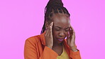 Headache, stress and anxiety with a black woman in studio on a pink background suffering from burnout. Mental health, pain and migraine with a young female rubbing her temples in discomfort