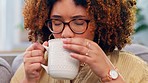 Black woman, relax and coffee on a sofa, happy and smile while thinking, chilling and enjoying the weekend. Tea, cheerful and girl on a couch in living room, peaceful and satisfied, content and calm