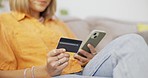 Phone, credit card and woman on a sofa doing online shopping on website retail store. Technology, ecommerce and hands of female paying bills with internet banking on cellphone in living room at home.